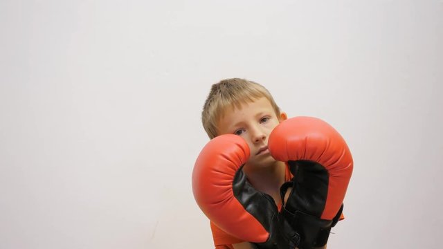 Bored child with box gloves, no mood to fight, pacifist kid 