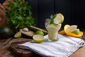 avocado smoothie and lime in a glass. Food for health and beauty. Super food from vegetables and fruits. Wooden background, free space for text.
