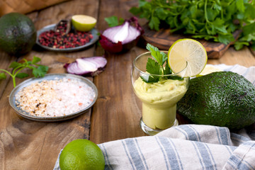 avocado smoothie and lime in a glass. Food for health and beauty. Super food from vegetables and fruits. Wooden background, free space for text.