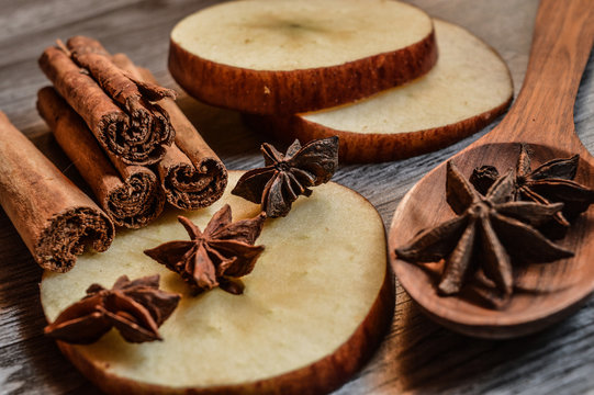 Star anise, cinnamon and apple on mader background.