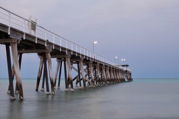 Morning photo of a jetty or pier with overcast skies and calm water