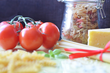 composition of healthy food ingredients on white background, top view. Ingredients for making macron, spaghetti, pasta. Tomatoes, basil, parmesan cheese, grater