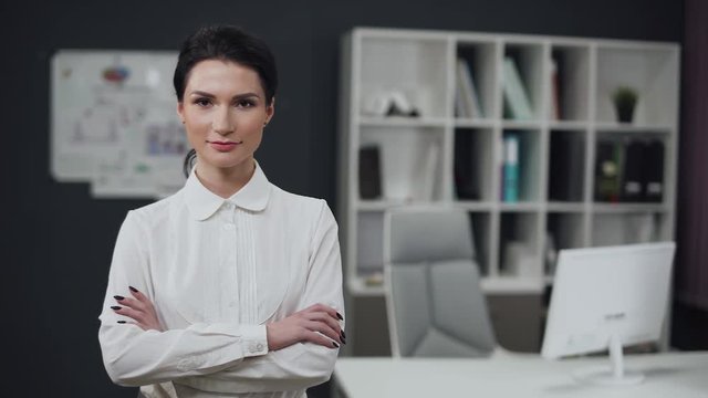 Businesswoman standing, office interior on background, female.