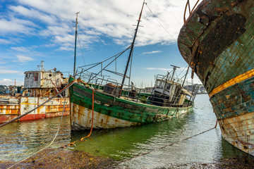 Fototapeta na wymiar rotting ships with peeling paint and rotten structures on the Cemetery boat in Brittany, France