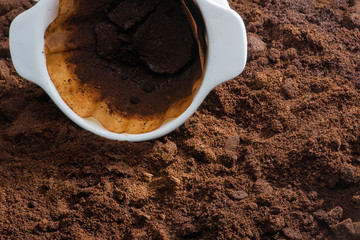 Kaffefilter und Papierfilter liegen auf Kaffesatz, close up