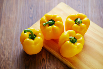 yellow bell peppers on wooden board