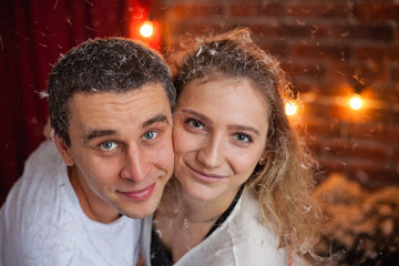 Loving couple man and woman on bed in feathers