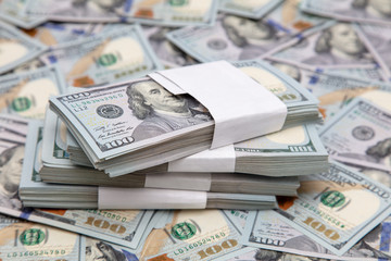 One hundred dollar bills on the table as background