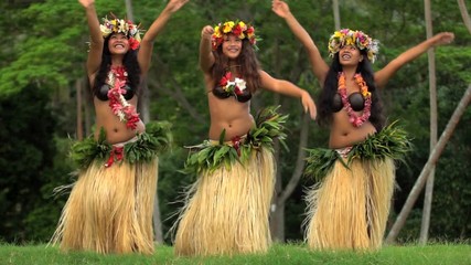 Group of beautiful young synchronized Polynesian female dancers entertaining in traditional costume barefoot outdoor French Polynesia South Pacific