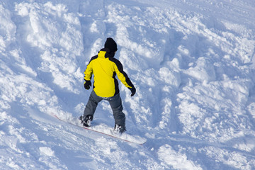 Fototapeta na wymiar A man snowboarding a mountain in the snow in winter