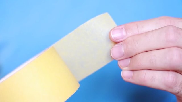 Adhesive tape in male hands closeup