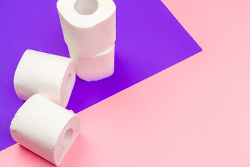 White toilet paper rolls on bright color block background