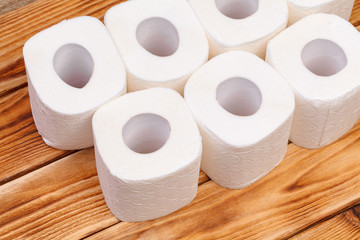 Toilet paper rolls on wooden background top view