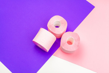 Pastel pink toilet paper on bright color block background