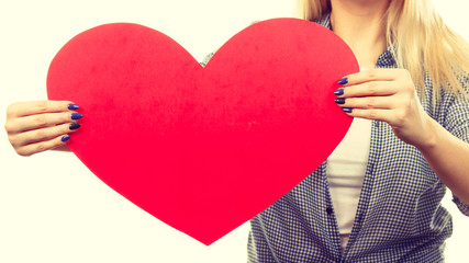 Woman holding big red heart, love sign