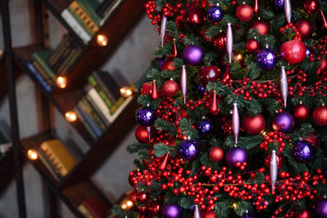 Winter decoration. decoration of the shelf for the new year or Christmas. candles, Christmas tree, books, bows and bumps