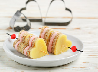 Mini sandwiches parmesan cheese ham bread on skewers in the form of hearts. Valentine's day....