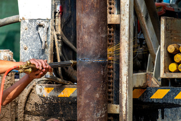 Mechanic Cutting Big Metal Tube with Gas Cutting Machine in the Borewell Digging Work Site