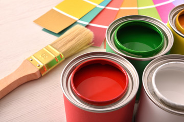 Colorful paint pots open and color palette on wood table