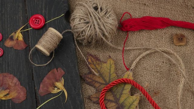 Decorative composition of accessories for sewing and needlework in the style of eco fashion on a wooden plank and burlap