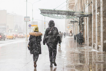 Naklejka premium people walk in city streets under snowall b