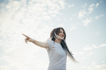 Happy smiling young woman in the city at the sunset