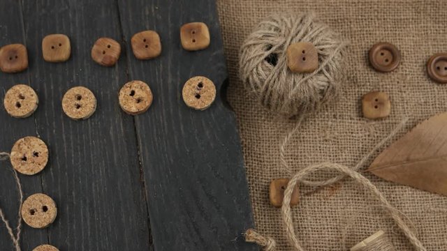 Decorative composition of accessories for sewing and needlework in the style of eco fashion on a wooden plank and burlap