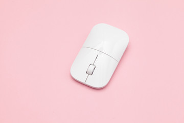 White wireless optical mouse with a wheel on a pink background. Modern concept for the Internet web site. Free space for input text, image, and logo. Mockup