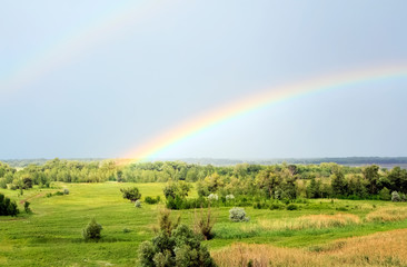 Double rainbow over the valley near the river after a rain at beautiful summer day