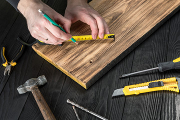 The carpenter works with wood on his workspace