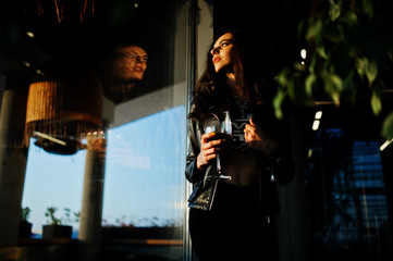 Fototapeta na wymiar Young curly woman enjoying her wine in a bar.