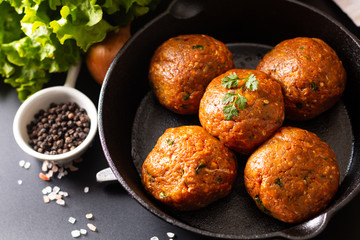 Food Homemade raw organic spicy meatball in iron cast on black background