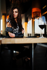 Young curly woman enjoying  her wine in a bar.