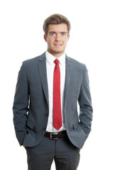 young man wearing suit and tie with hands in pockets