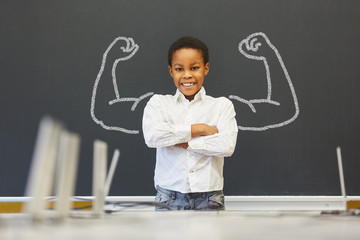 Afrikanisches Kind vor Tafel mit Muskeln