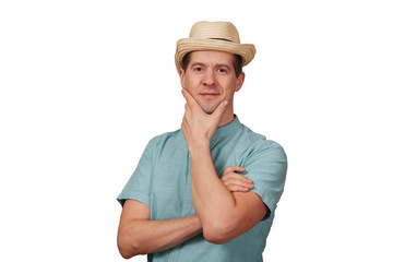 The man in a shirt and a hat holds a hand a chin
