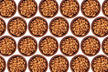 Peeled  almond  in a wooden cedar plate on a white isolated background. Row of bowls with almond  nuts, top view. Peeled  almond pattern