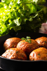 Food Homemade raw organic spicy meatball in iron cast on black background