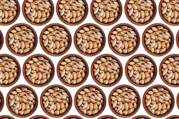 Unpeeled almonds Badam in a wooden cedar plate on a white isolated background. Row of bowls with almonds Badam, top view. Unpeeled almonds Badam pattern