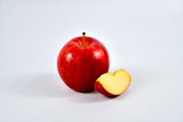 Red apple and slice on a white background.