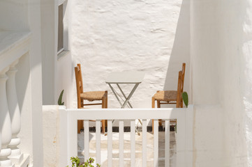 Minimal scenic at Andros island in Greece with two chairs and a table.