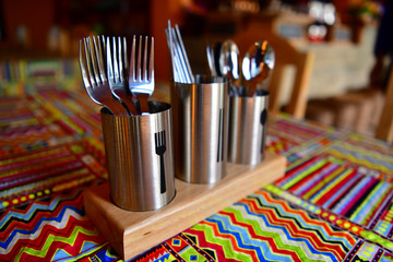 Cutlery and chopsticks are included in stainless steel tanks on the table.