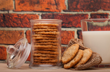 Fototapeta na wymiar Oatmeal cookies with milk on the oak table