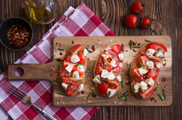 Italian bruschetta: bread with tomatoes, mozzarella and spices