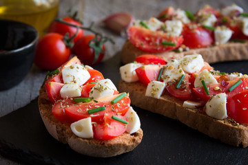 Italian bruschetta: bread with tomatoes, mozzarella and spices