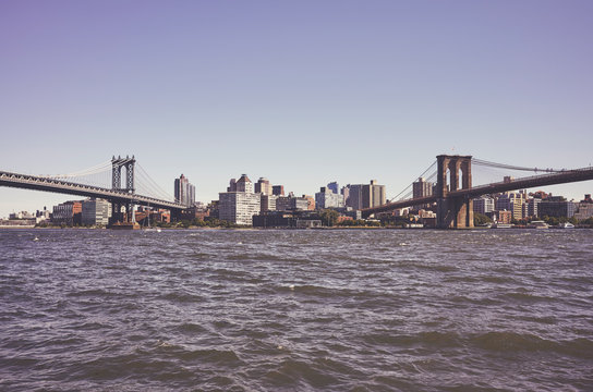 Brooklyn Borough seen between two famous New York bridges, Manhattan Bridge and Brooklyn Bridge, retro color toned picture, USA.
