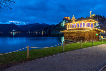 Night on Lake Bled. Christmas atmosphere and lights. Castle and Church of the Annunciation