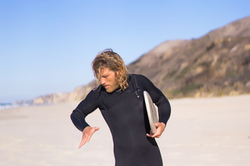 surfer with flippers and a bodyboard in a hydro suit on the ocean shore