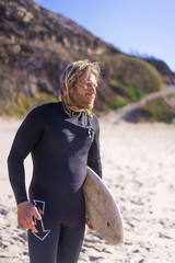 surfer with flippers and a bodyboard in a hydro suit on the ocean shore