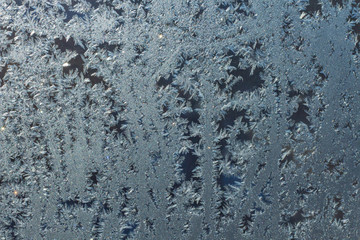 Ice patterns on glass, frost on a winter window, fancy patterns of winter.